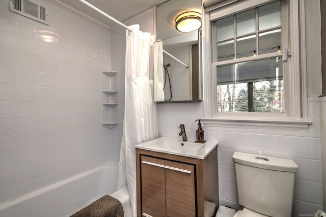 full bath featuring toilet, shower / bath combination with curtain, vanity, and tile walls