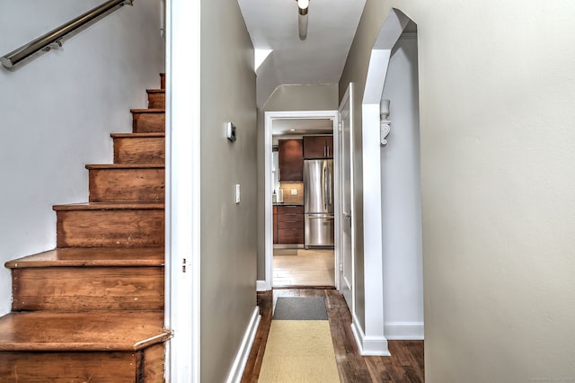staircase featuring wood finished floors and baseboards