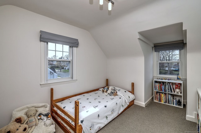 carpeted bedroom with vaulted ceiling, baseboards, and a ceiling fan