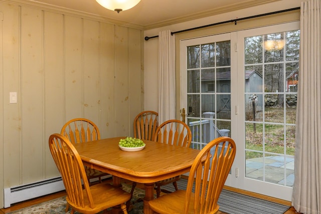 dining space with plenty of natural light, crown molding, and baseboard heating