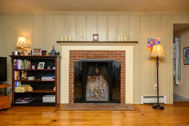 room details featuring wood finished floors, a fireplace, and a baseboard radiator