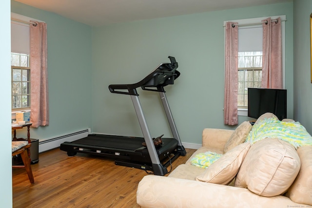 workout area with a baseboard radiator and wood finished floors