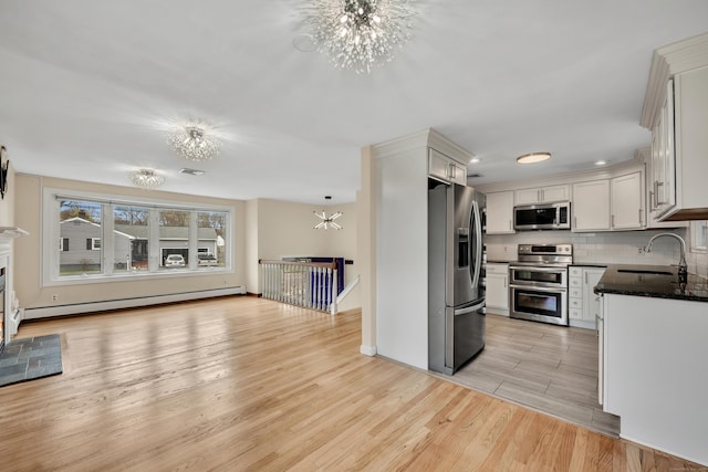 120 Newton St, Berlin, CT 06037 - kitchen with light wood finished floors, stainless steel appliances, a sink, an inviting chandelier, and a baseboard radiator