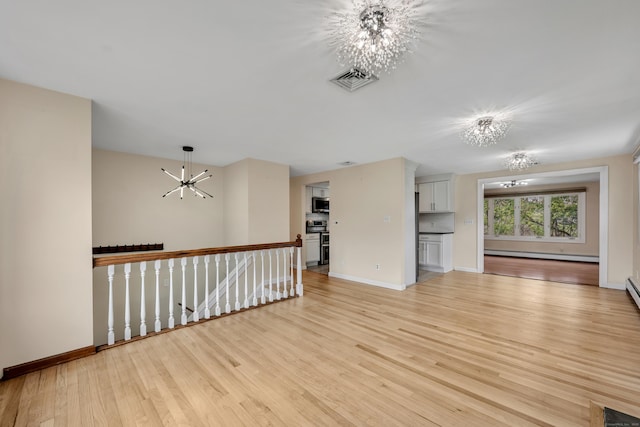 120 Newton St, Berlin, CT 06037 - unfurnished living room featuring a baseboard heating unit, light wood-style floors, baseboards, a notable chandelier, and visible vents