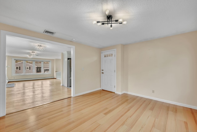 120 Newton St, Berlin, CT 06037 - unfurnished room with a baseboard radiator, an inviting chandelier, wood finished floors, and visible vents