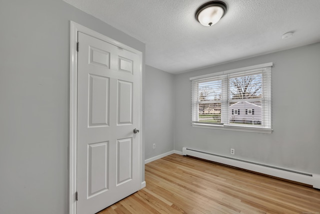 120 Newton St, Berlin, CT 06037 - unfurnished bedroom featuring a baseboard radiator, light wood-style flooring, a textured ceiling, and baseboards