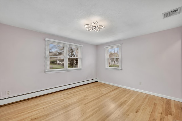 120 Newton St, Berlin, CT 06037 - spare room with a baseboard heating unit, baseboards, wood finished floors, and visible vents