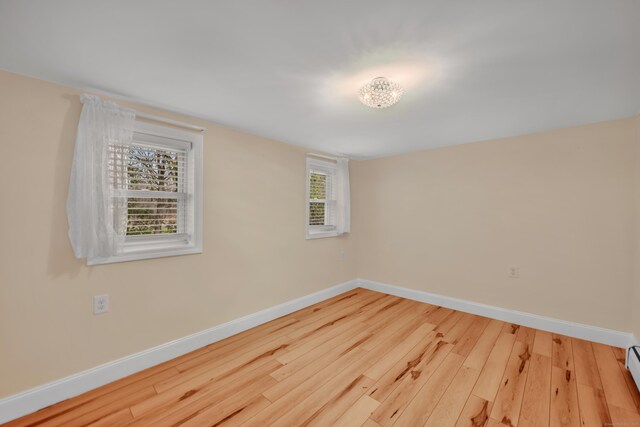 120 Newton St, Berlin, CT 06037 - unfurnished room with wood finished floors, plenty of natural light, and a baseboard radiator