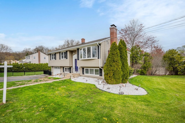 120 Newton St, Berlin, CT 06037 - raised ranch with a front lawn, driveway, a chimney, fence, and an attached garage
