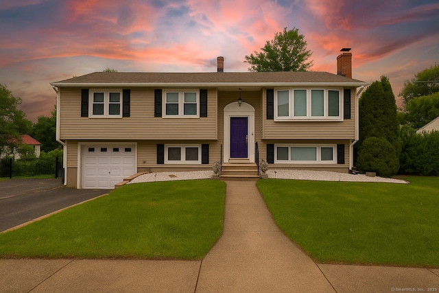 120 Newton St, Berlin, CT 06037 - bi-level home featuring driveway, a chimney, a lawn, and a garage