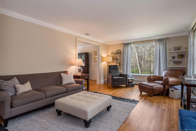 living room with wood-type flooring, crown molding, and baseboard heating