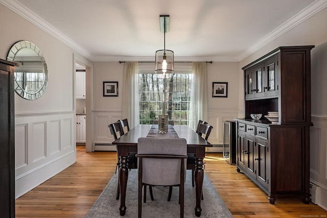 dining room with ornamental molding, a decorative wall, and baseboard heating