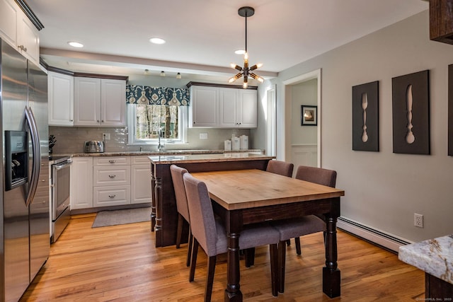 dining space with recessed lighting, a chandelier, light wood-type flooring, and a baseboard radiator