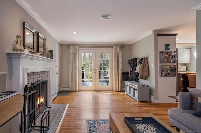 living area featuring ornamental molding, baseboard heating, and a fireplace