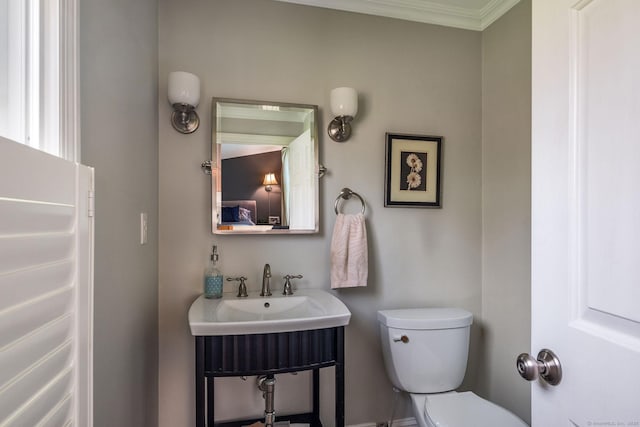 bathroom featuring crown molding and toilet