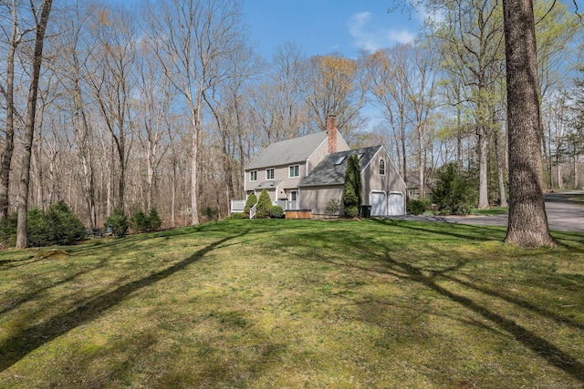 view of yard featuring an attached garage and driveway