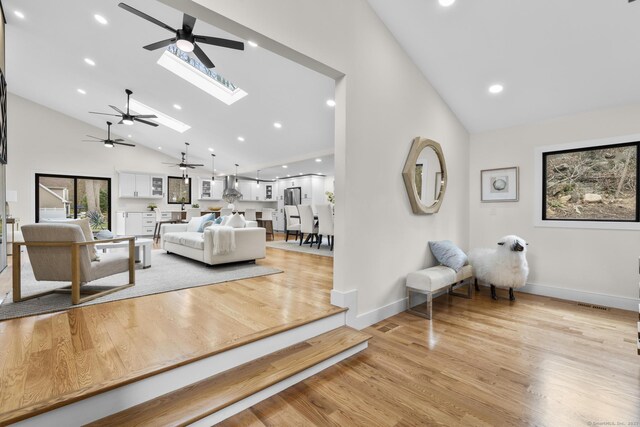 35 Bayberry Ln, Guilford, CT 06437 - living room featuring baseboards, light wood-style flooring, high vaulted ceiling, and ceiling fan