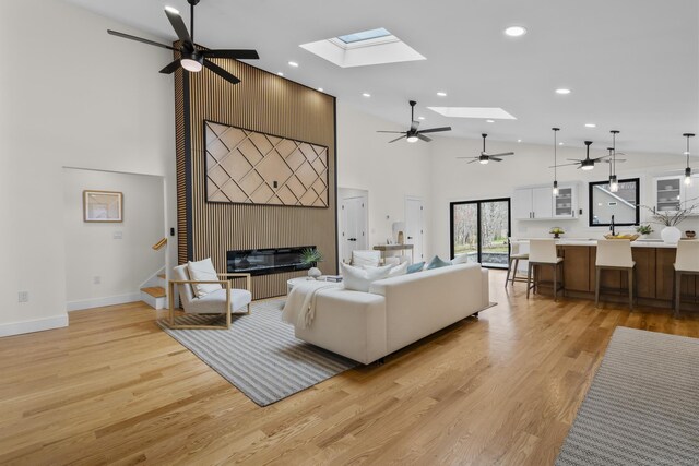 35 Bayberry Ln, Guilford, CT 06437 - living room with high vaulted ceiling, a ceiling fan, a skylight, light wood finished floors, and a fireplace