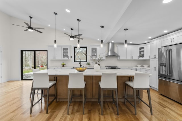 35 Bayberry Ln, Guilford, CT 06437 - kitchen with wall chimney exhaust hood, recessed lighting, white cabinetry, light wood-style floors, and high end fridge