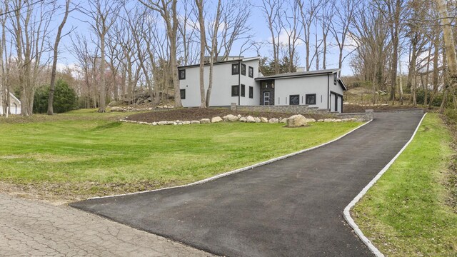 35 Bayberry Ln, Guilford, CT 06437 - view of front of home with stucco siding, a front lawn, and driveway