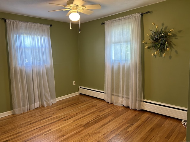 spare room with baseboards, a ceiling fan, and wood finished floors