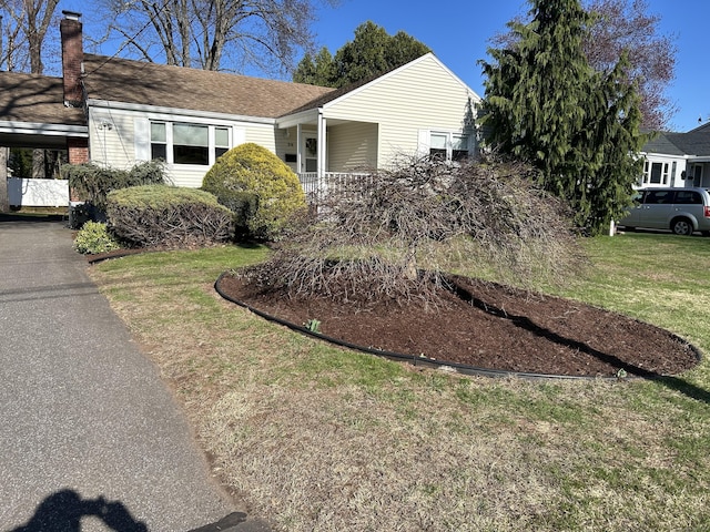 view of front of house with a chimney and a front lawn