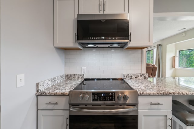 231 Heritage Vlg Unit C, Southbury, CT 06488 - kitchen featuring electric range, backsplash, light stone counters, and a peninsula