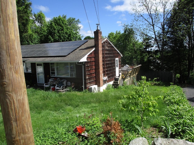 37 Foley Ave, Shelton, CT 06484 - view of home's exterior with a shingled roof, roof mounted solar panels, and a chimney