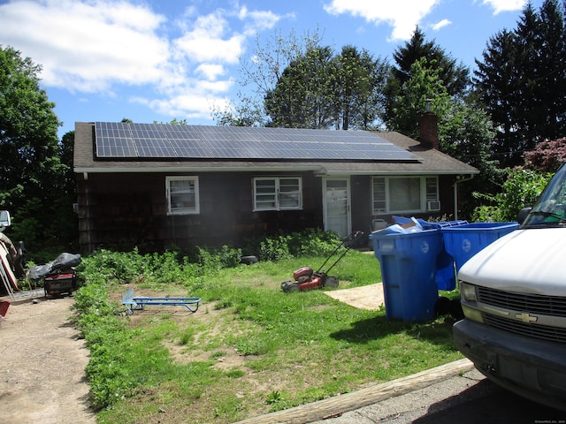 37 Foley Ave, Shelton, CT 06484 - view of front of property with roof mounted solar panels, a chimney, roof with shingles, and a front yard