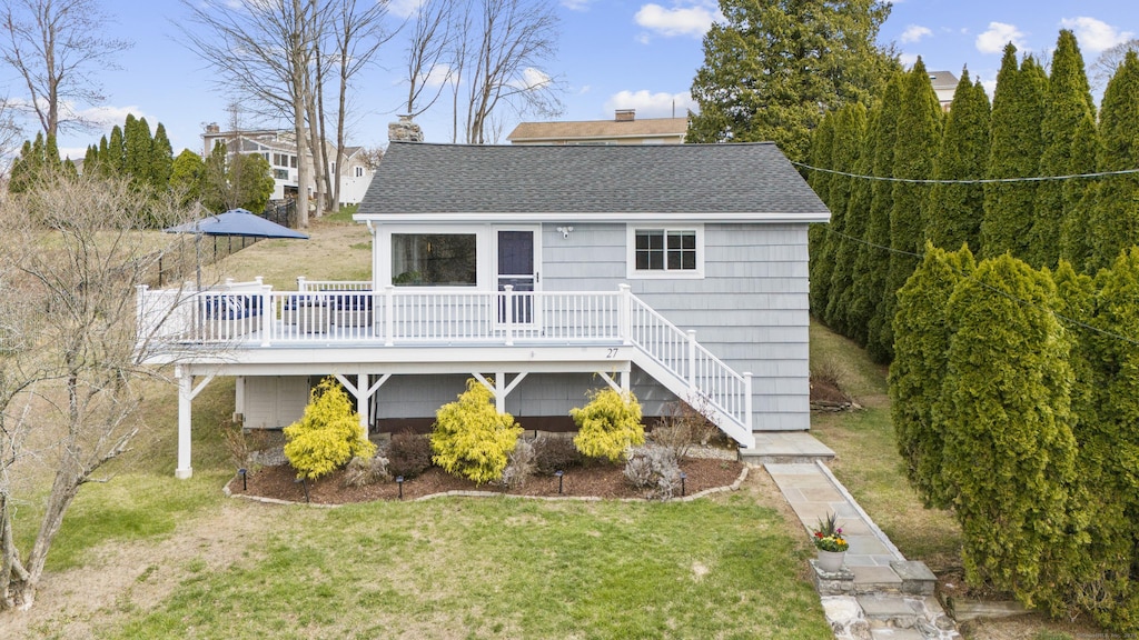back of house featuring a yard, stairway, a deck, and a shingled roof