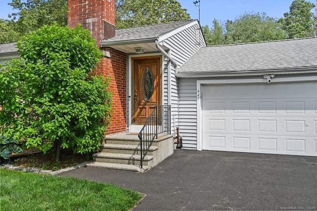 447 Howellton Rd, Orange, CT 06477 - doorway to property featuring a shingled roof, a chimney, an attached garage, and asphalt driveway