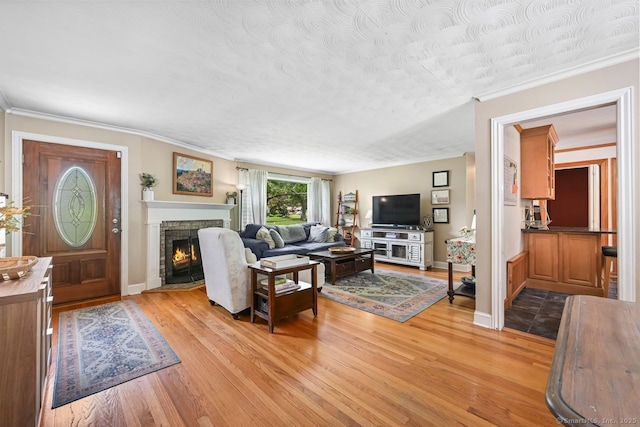 447 Howellton Rd, Orange, CT 06477 - living room featuring light wood finished floors, a fireplace, ornamental molding, and a textured ceiling