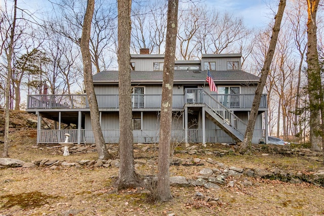 259 Weatherly Trl, Guilford, CT 06437 - rear view of property with stairway, a wooden deck, a shingled roof, and a chimney