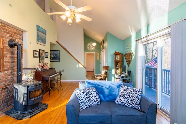 259 Weatherly Trl, Guilford, CT 06437 - living room featuring wood finished floors, a wood stove, a ceiling fan, and a healthy amount of sunlight