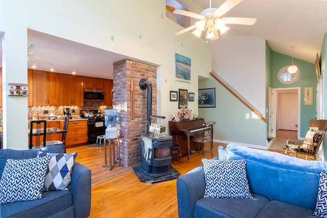 259 Weatherly Trl, Guilford, CT 06437 - living area featuring a wood stove, stairs, light wood-type flooring, high vaulted ceiling, and ceiling fan