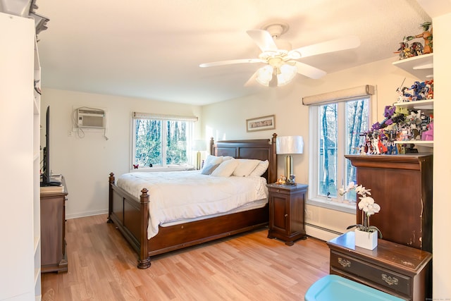 259 Weatherly Trl, Guilford, CT 06437 - bedroom with a baseboard radiator, light wood-style floors, a wall mounted air conditioner, and a ceiling fan