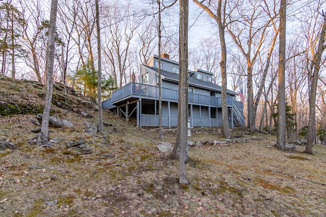 259 Weatherly Trl, Guilford, CT 06437 - rear view of house with a wooden deck, a shingled roof, a chimney, and stairway