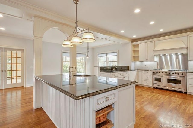 kitchen with open shelves, ornamental molding, dark countertops, custom range hood, and range with two ovens