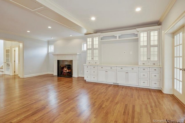 unfurnished living room featuring light wood-style floors, crown molding, and a healthy amount of sunlight