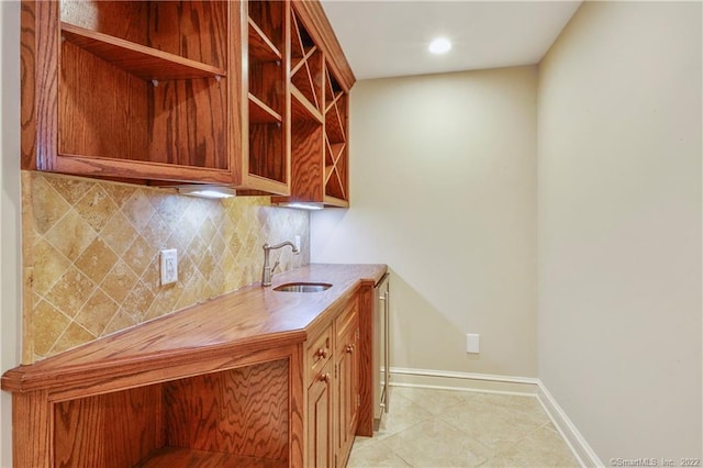 unfurnished office with light tile patterned flooring, a sink, baseboards, and recessed lighting