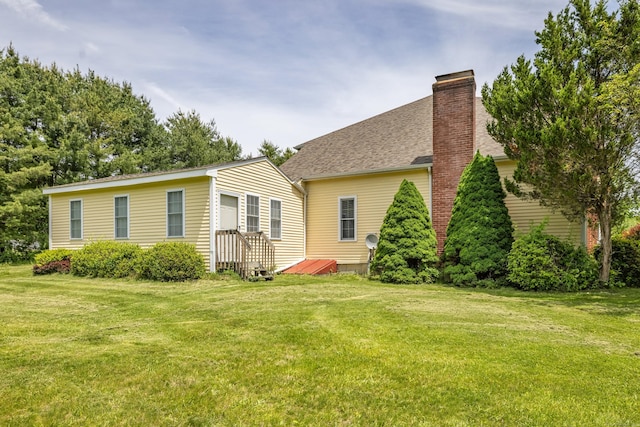 14 Fieldstone Dr, Mansfield, CT 06268 - back of house with a chimney, a lawn, and roof with shingles