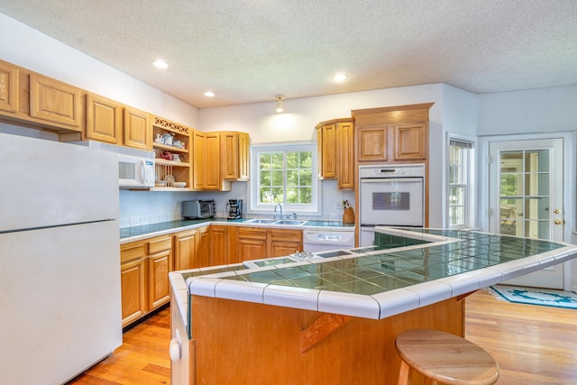 14 Fieldstone Dr, Mansfield, CT 06268 - kitchen featuring white appliances, a textured ceiling, light wood-type flooring, tile counters, and open shelves