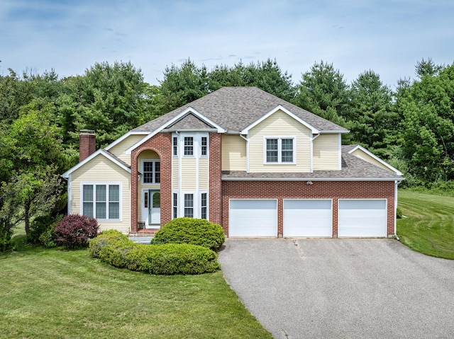14 Fieldstone Dr, Mansfield, CT 06268 - traditional-style house featuring driveway, a front lawn, a shingled roof, and brick siding