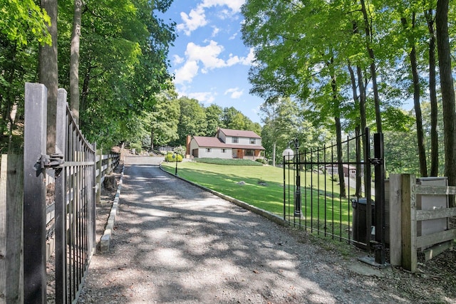 view of gate featuring fence and a lawn
