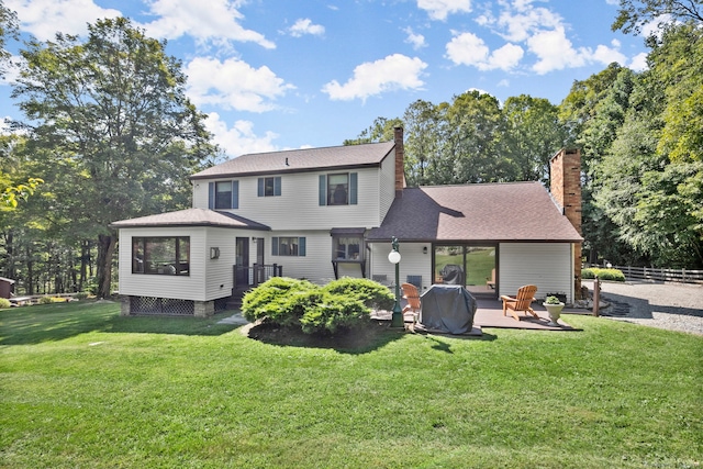 rear view of house featuring a wooden deck, a yard, a shingled roof, and fence