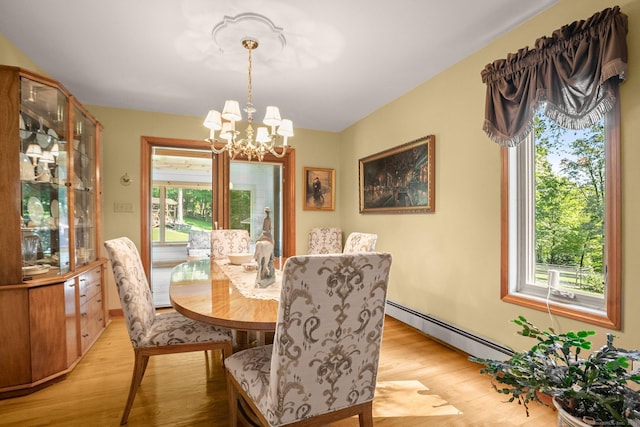 dining room featuring a notable chandelier, light wood finished floors, and baseboard heating