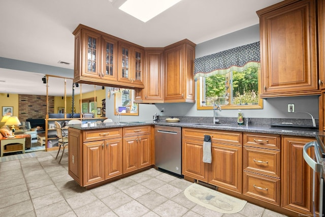 kitchen with a sink, brown cabinetry, a peninsula, and dishwasher