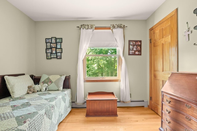 bedroom featuring light wood-style flooring and a baseboard radiator