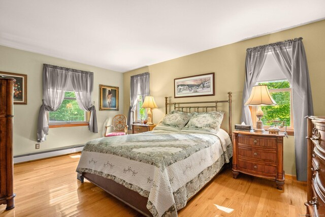 bedroom featuring light wood-type flooring and baseboard heating