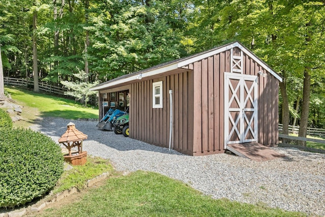 view of outdoor structure featuring fence and an outbuilding